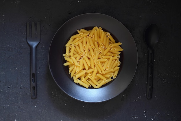 Photo pâtes italiennes sur un plat rond sur fond noir