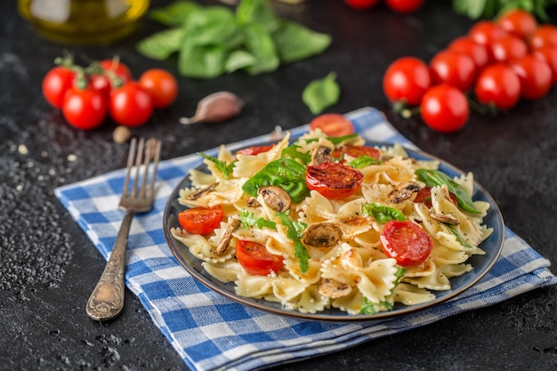 Pâtes italiennes avec sauce, tomates cerises, basilic et parmesan. Délicieuse assiette de pâtes