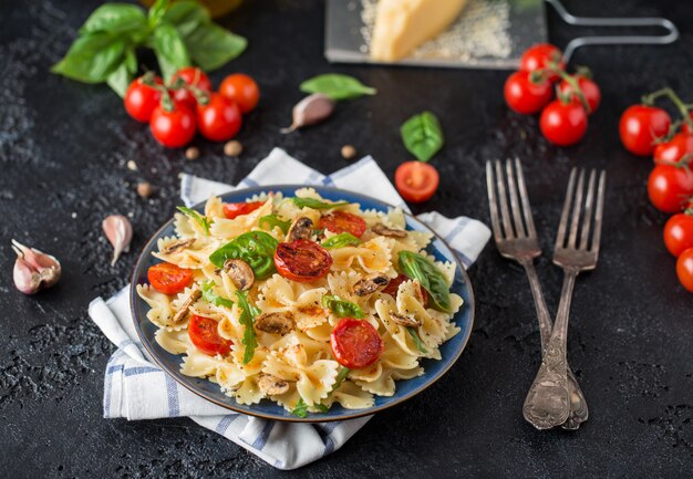 Pâtes italiennes avec sauce, tomates cerises, basilic et parmesan. Délicieuse assiette de pâtes