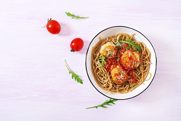 Pâtes italiennes. Spaghetti aux boulettes de viande et parmesan dans un bol sur fond de bois rustique clair. Dîner. Vue de dessus. Concept de slow food