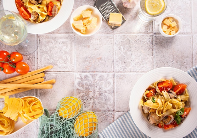 Pâtes italiennes traditionnelles aux fruits de mer avec vongole de palourdes avec verre de vin blanc et autres ingrédients