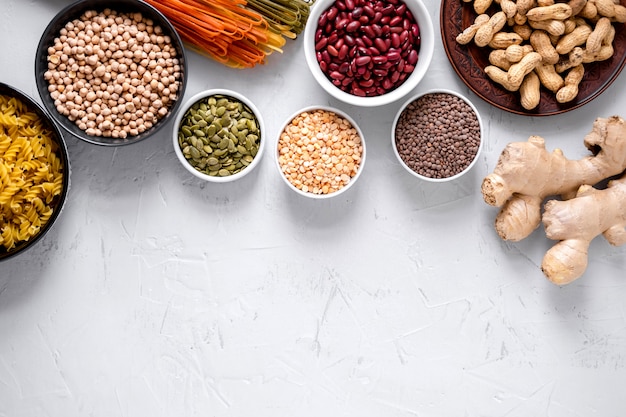 Pâtes, lentilles, racine de gingembre, pois chiches et haricots dans des bols Vue de dessus. Copiez l'espace.