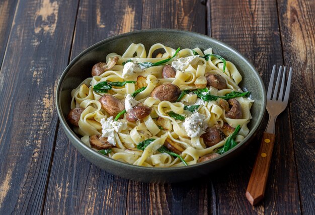 Pâtes linguines aux champignons, fromage blanc, épinards et ail. Alimentation équilibrée. La nourriture végétarienne. Régime.