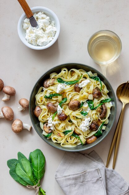 Pâtes linguines aux champignons, fromage blanc, épinards et ail. Alimentation équilibrée. La nourriture végétarienne. Régime.