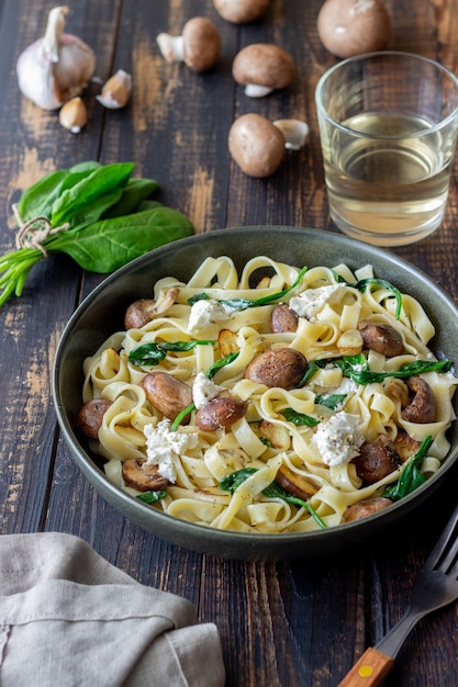 Pâtes linguines aux champignons, fromage blanc, épinards et ail. Alimentation équilibrée. La nourriture végétarienne. Régime.