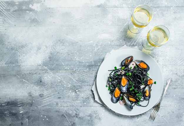 Photo pâtes méditerranéennes spaghetti aux palourdes à l'encre de seiche et au vin blanc