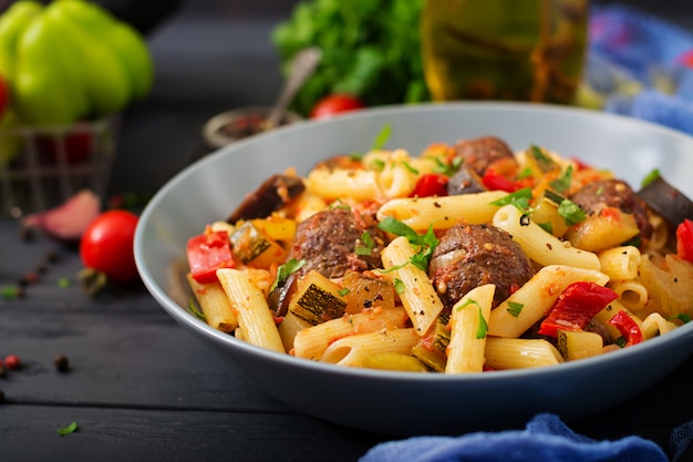 Pâtes penne aux boulettes de viande à la sauce tomate et légumes dans un bol