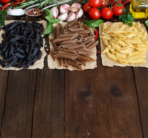 Pâtes Penne Aux Légumes, Herbes Et Huile D'olive Sur Fond De Bois