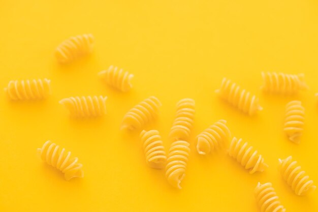 Pâtes penne isolées sur jaune d'en haut