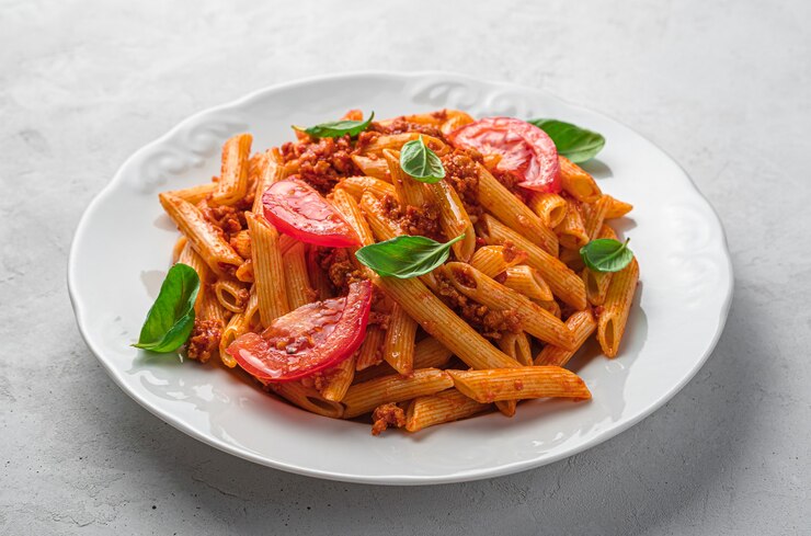 Photo pâtes penne à la sauce bolognaise sur fond gris. cuisine italienne. vue latérale, gros plan.