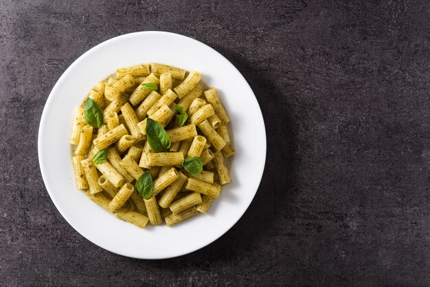 Pâtes penne à la sauce pesto sur fond noir