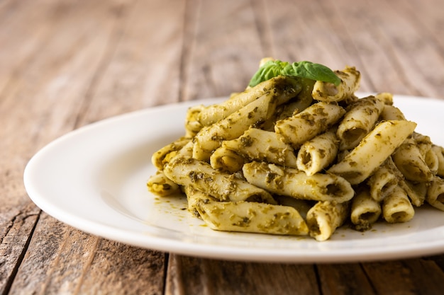 Pâtes penne avec sauce pesto sur table en bois