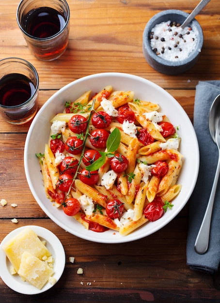 Pâtes penne à la tomate rôtie, sauce, mozzarella et basilic frais. Vue de dessus.