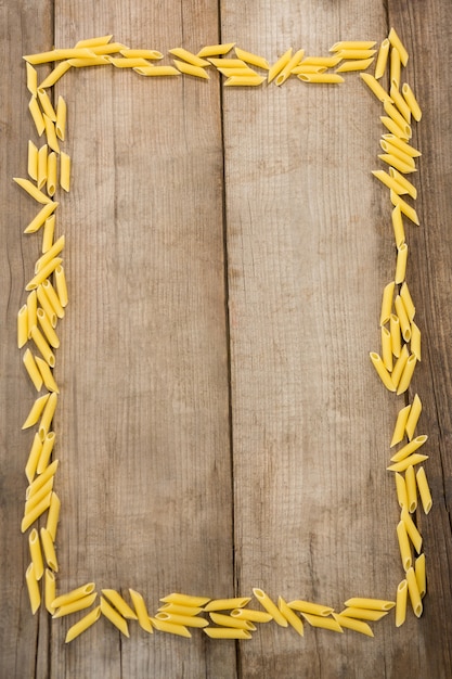 Pâtes Pennette formant cadre sur surface en bois