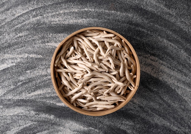 Pâtes des Pouilles de blé entier appelées Pizzarieddi ou maccaruni sur tableau noir. Fond de pâtes italiennes faites maison