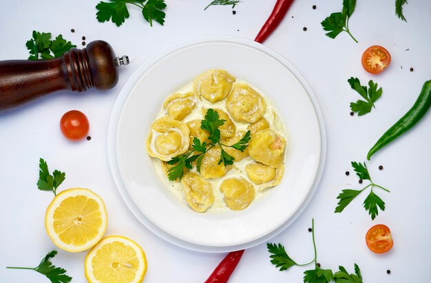 Pâtes raviolis traditionnels italiens avec de la viande ou du poisson d'esturgeon sur fond blanc