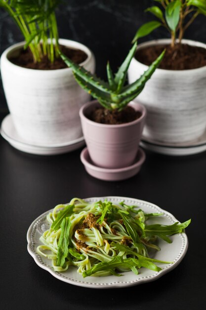 Pâtes à la roquette et au pesto sur l'assiette, tableau noir