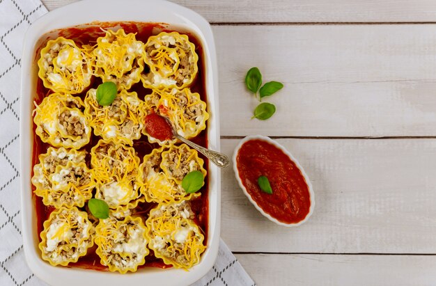 Pâtes roulées avec viande hachée et sauce tomate dans une plaque à pâtisserie.