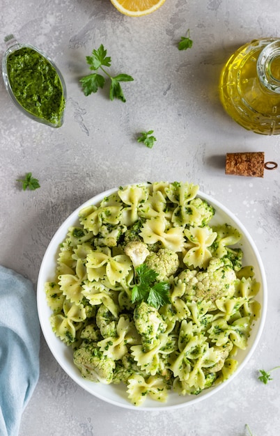 Pâtes à La Sauce Verte Et Le Chou-fleur Rôti Sur Une Assiette Blanche. Espace De Copie.