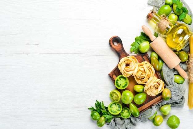 Pâtes sèches tomates verts huile et ingrédients Cuisine traditionnelle italienne Légumes frais Vue de dessus Espace libre pour votre texte