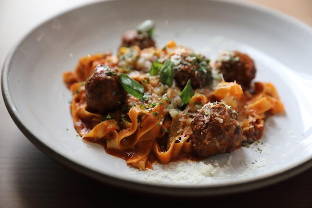 Pâtes spaghetti aux boulettes de boeuf et sauce tomate sur fond de bois. nourriture italienne