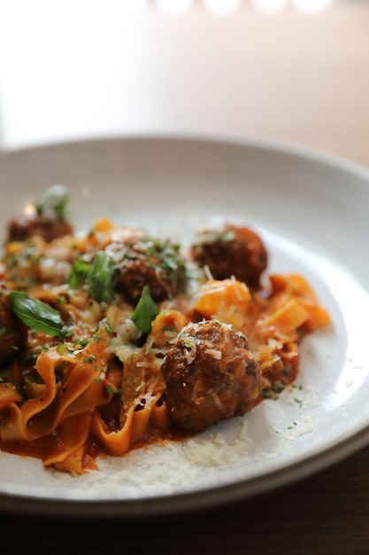 Pâtes spaghetti aux boulettes de boeuf et sauce tomate sur fond de bois. nourriture italienne