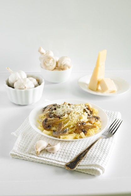 pâtes spaghetti aux champignons et parmesan dans une sauce crémeuse sur un tableau blanc