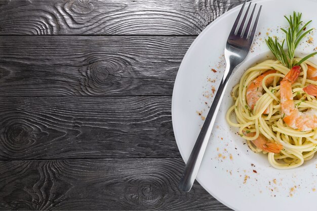 Pâtes spaghetti aux crevettes sur table.