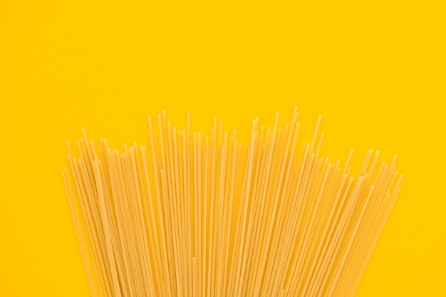 Photo pâtes spaghetti sur fond jaune d'en haut