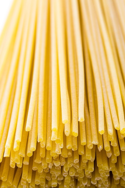 Pâtes spaghetti jaune biologique sur fond blanc.