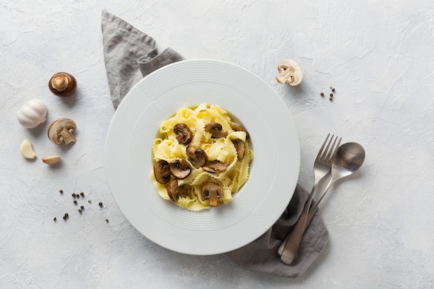 Pâtes spaghetti reginelle aux champignons sur blanc. Savoureux dîner sain.