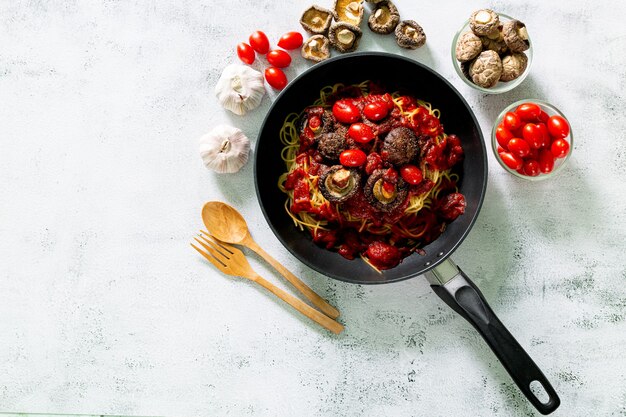 Pâtes spaghetti à la sauce tomate avec poulet persil dans une poêle