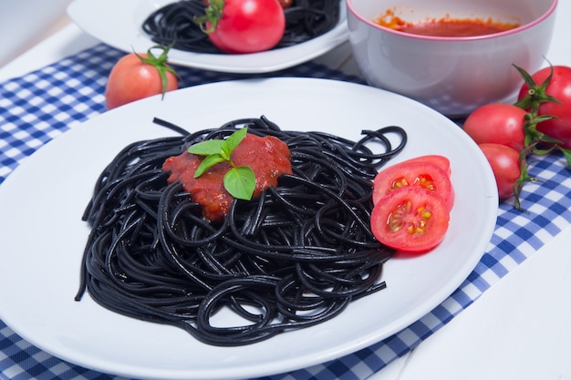 Pâtes spaghettis et sauce tomate sur fond de bois