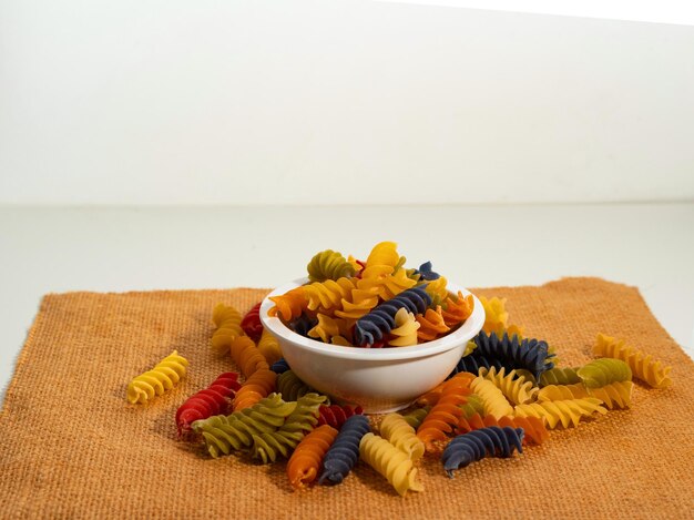 Photo pâtes en spirale multicolores dans une tasse sur la table