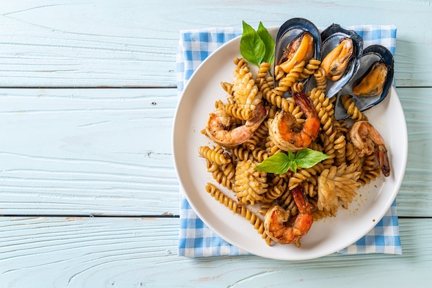 pâtes en spirale sautées aux fruits de mer et sauce au basilic - style cuisine fusion