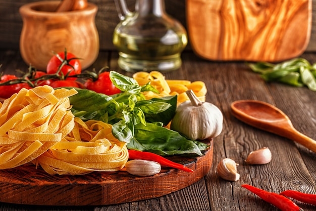 pâtes, tomates, ail, poivron et basilic sur le vieux bois.