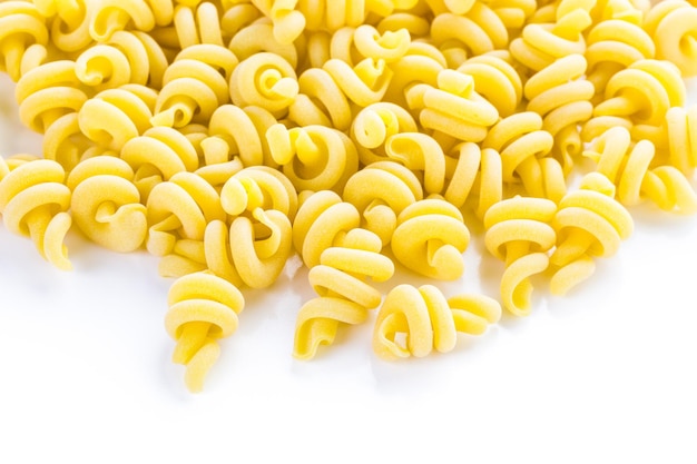 Pâtes trottole italiennes jaunes biologiques sur fond blanc.