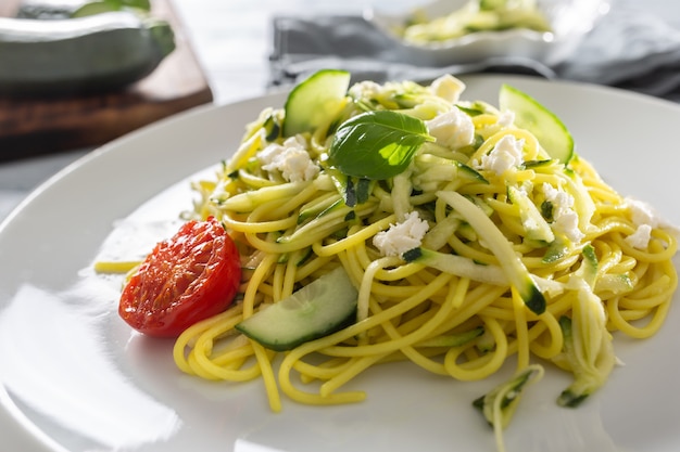 Pâtes végétaliennes crues aux courgettes spaghetti avec concombre et basilic au fromage feta.