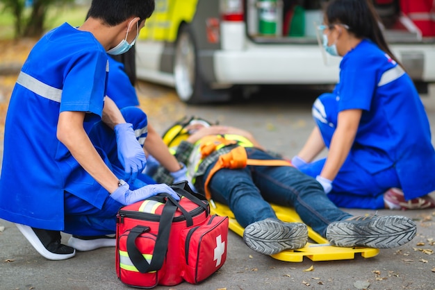 Patient accidenté d'urgence A souffert sur la tête allongée sur une civière. Formation aux premiers secours et déplacement du patient en cas d'accident d'urgence. Un ambulancier transfère un patient à une ambulance. Sélectionnez Focus sur la trousse de premiers soins.