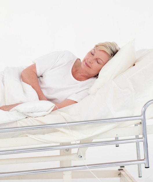 Patient âgé dans un lit blanc