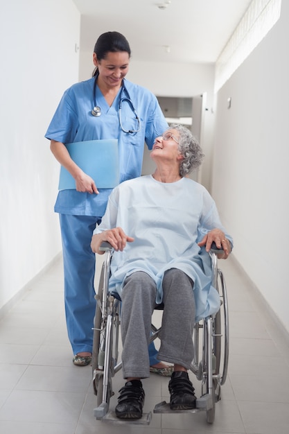 Patient âgé en fauteuil roulant regardant une infirmière