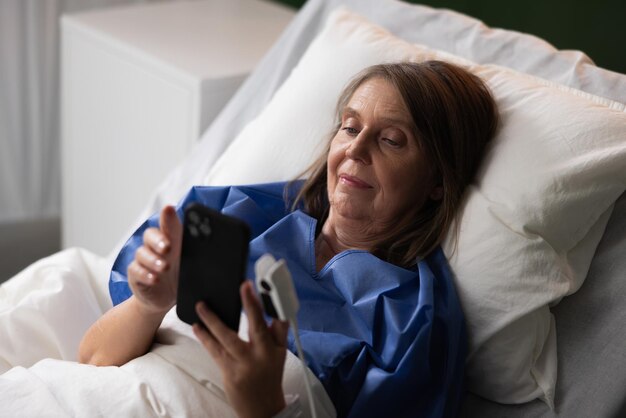 Photo patient âgé à l'hôpital tenant un téléphone