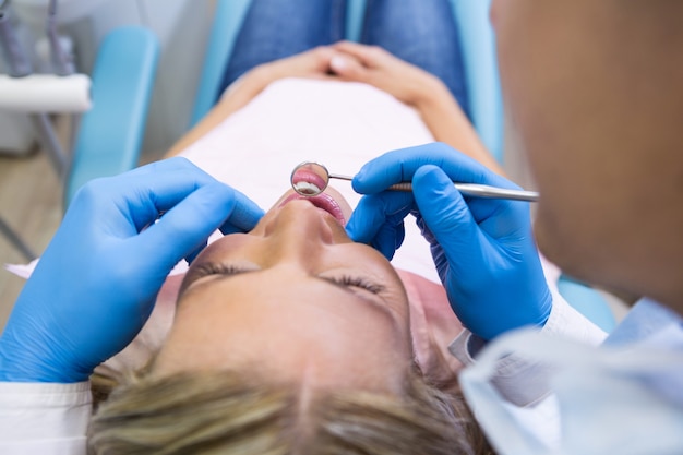 Patient allongé sur le lit pendant que le dentiste examine à la clinique