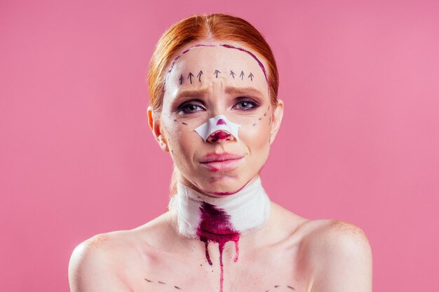 Patient en bandages Infirmières et jeune femme en studio fond rose