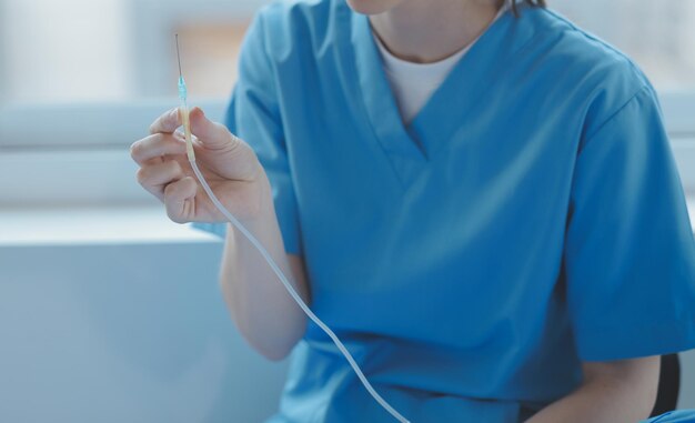 Patient blessé montrant au médecin un poignet et un bras cassés avec un bandage au bureau de l'hôpital ou à la salle d'urgence Entorse fracture de stress ou microtraumatismes répétés dans la main Infirmière aidant le client Premiers soins