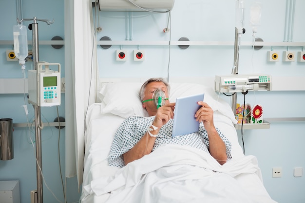 Patient couché dans son lit portant un masque de bœuf en lisant