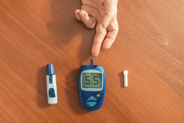 Patient diabétique hypoglycémique testant son sang pour le niveau de sucre à la maison faible taux de sucre dans le sang