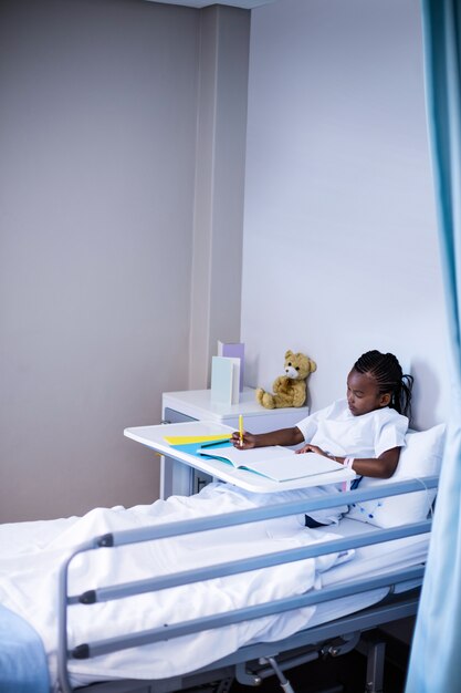 Patient écrit sur le livre en position assise