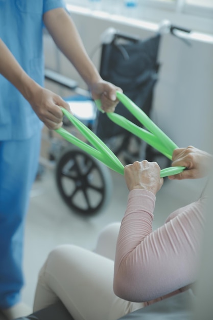 Photo patient faisant des exercices spéciaux sous surveillance dans une chambre