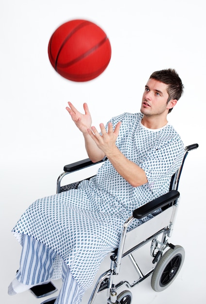 Patient en fauteuil roulant jouant avec un ballon de basket